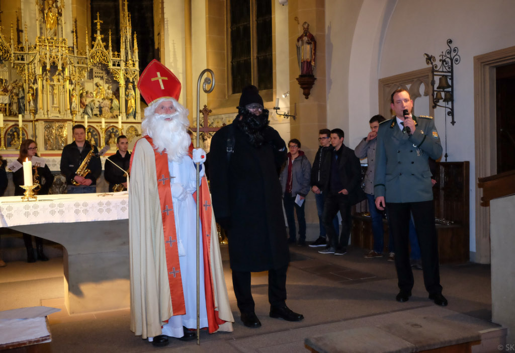<p>Marc Igges bedankt sich beim Nikolaus für seinen Besuch und begrüßt die Kinder, Eltern und Großeltern in der Kirche. Der Schützenverein Alfen sponsert die Nikolausfeier schon seit Jahrzehnten. Einige der anwesenden Großeltern können sich noch daran erinnern, selbst als Kind dabei gewesen zu sein. </p>